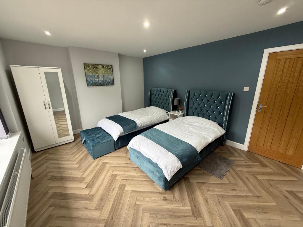 a bedroom with two beds and a mirror at Luxurious 3 bedrooms flat near New Cross,Wolverhampton No Parties or events in Wednesfield
