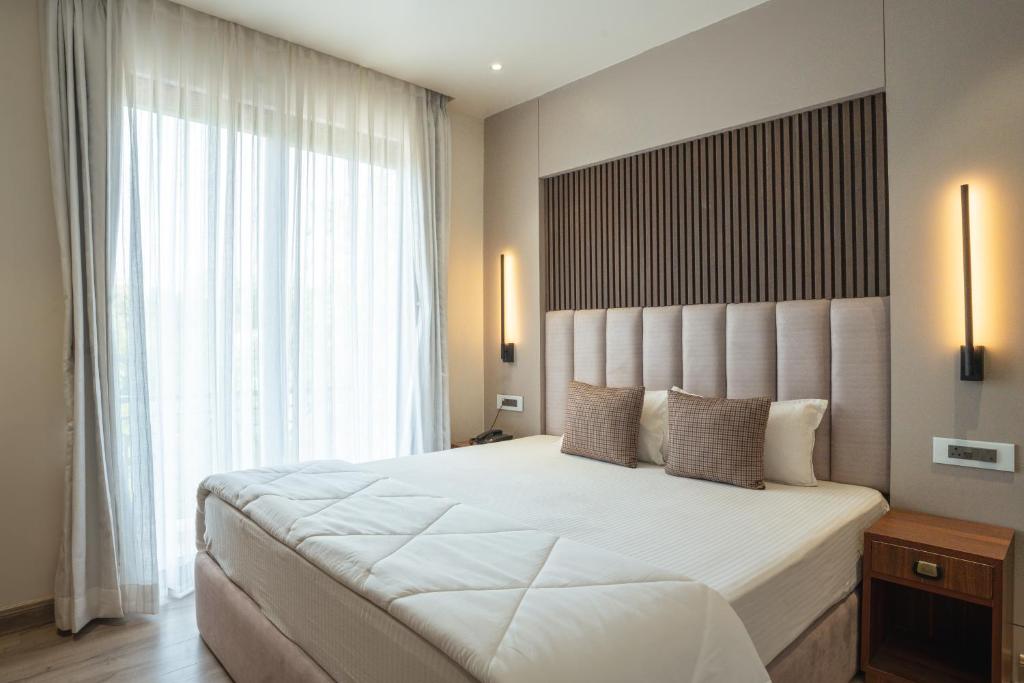 a bedroom with a large bed and a large window at White House Royal Living in Jhānsi