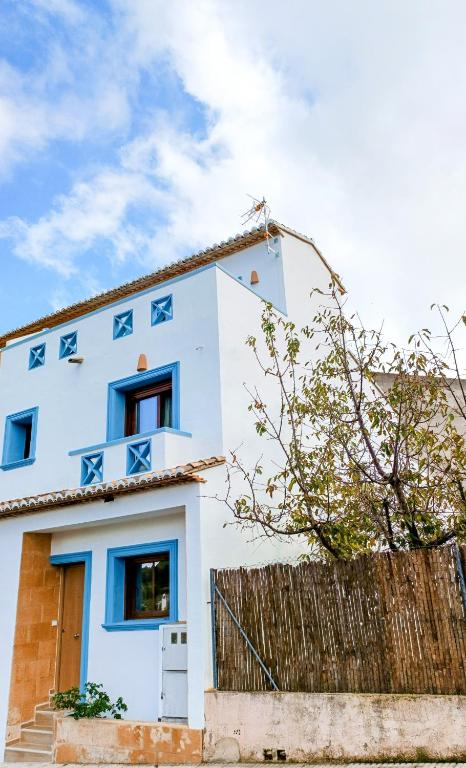 a white house with blue arrows on it at l'Alqueria de Laguar - Casa rural al Barranc de l'Infern in Benimaurell