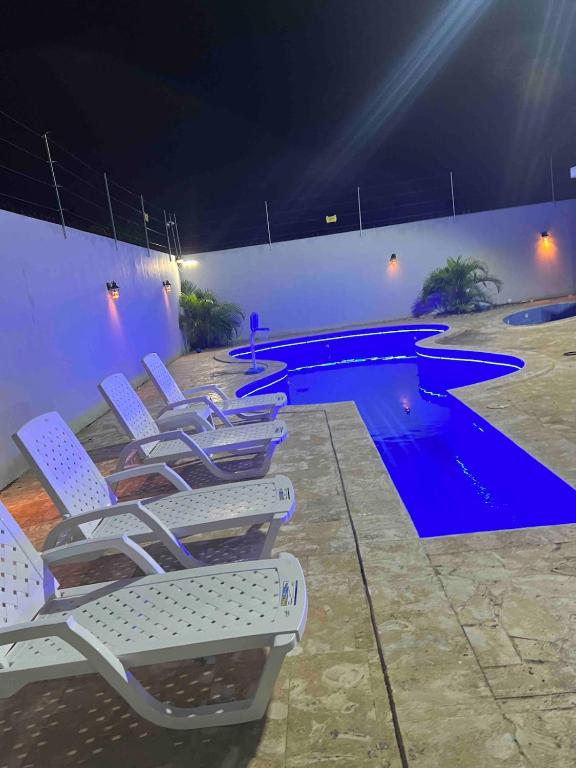 a group of lounge chairs next to a swimming pool at Villa Gordon in Santa Cruz de Barahona