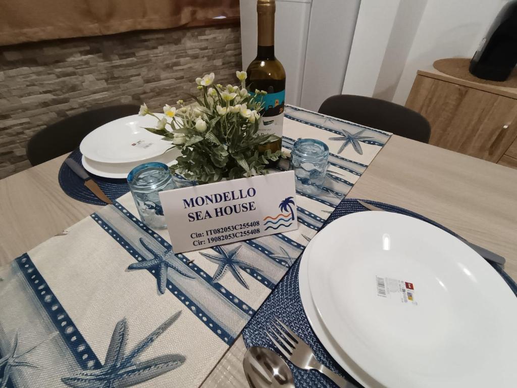 a table with a bottle of wine and a plate at Mondello Sea House in Palermo