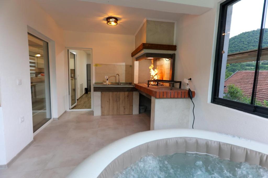 a bathroom with a tub and a kitchen with a sink at Holiday Residence Šehić in Visoko