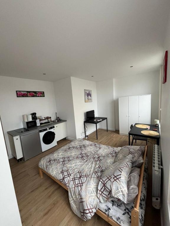 Cet appartement comprend une chambre avec un lit et une cuisine. dans l'établissement Cosy neuf avec vue sur la place, à Cambrai
