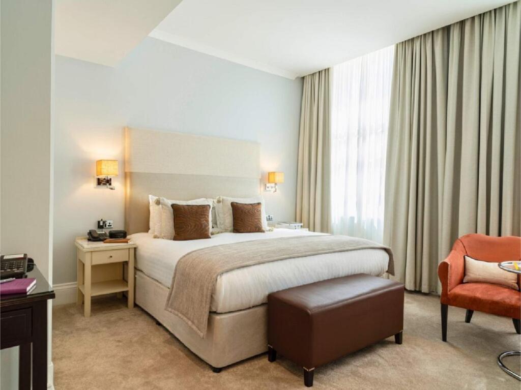 a hotel room with a bed and a chair at Hotel Delta Near Delhi AIRPORT in New Delhi