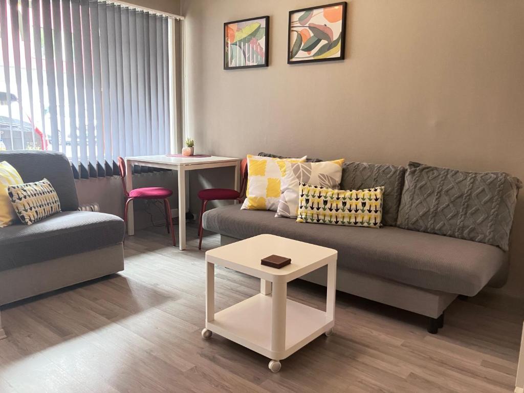 a living room with a couch and a table at Sentralt beliggende studioleilighet in Gol