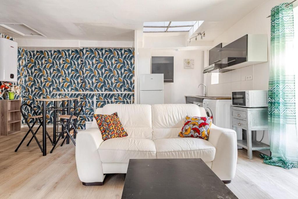 un salon avec un canapé blanc et une cuisine dans l'établissement Appartement 2 chambres Cosy proche Centre Ville, à Clermont-Ferrand