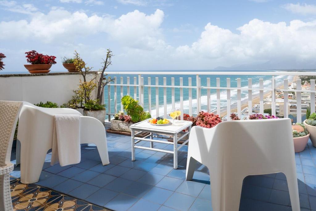 a balcony with tables and chairs and a view of the ocean at Casa Celeste Sperlongaresort in Sperlonga