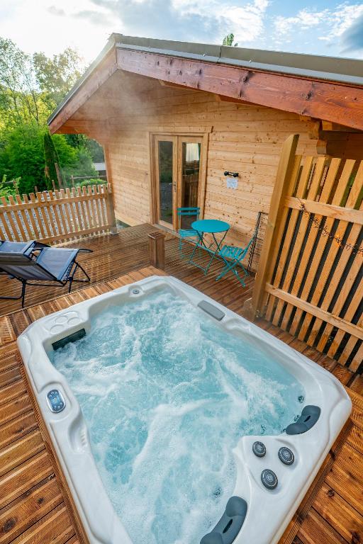 a hot tub on a deck with a cabin at Les Lodges de la Valière in Chorges