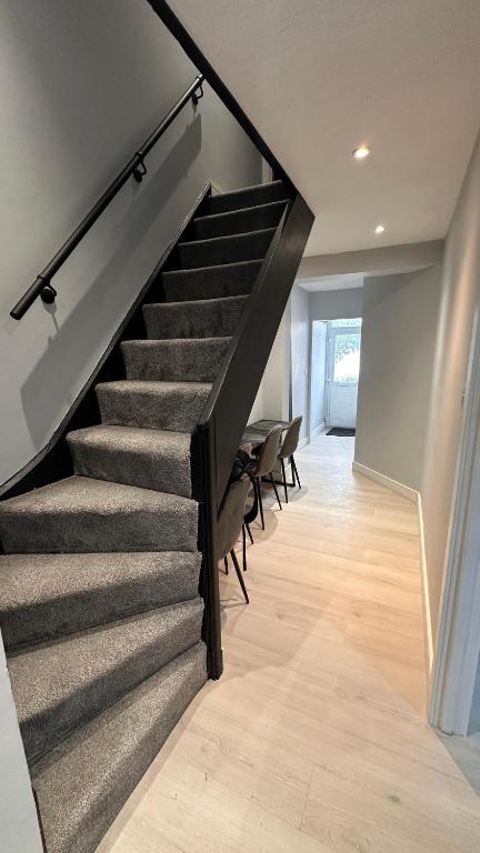 a staircase in a house with chairs in a room at Modern bedroom near town centre in Bridgwater