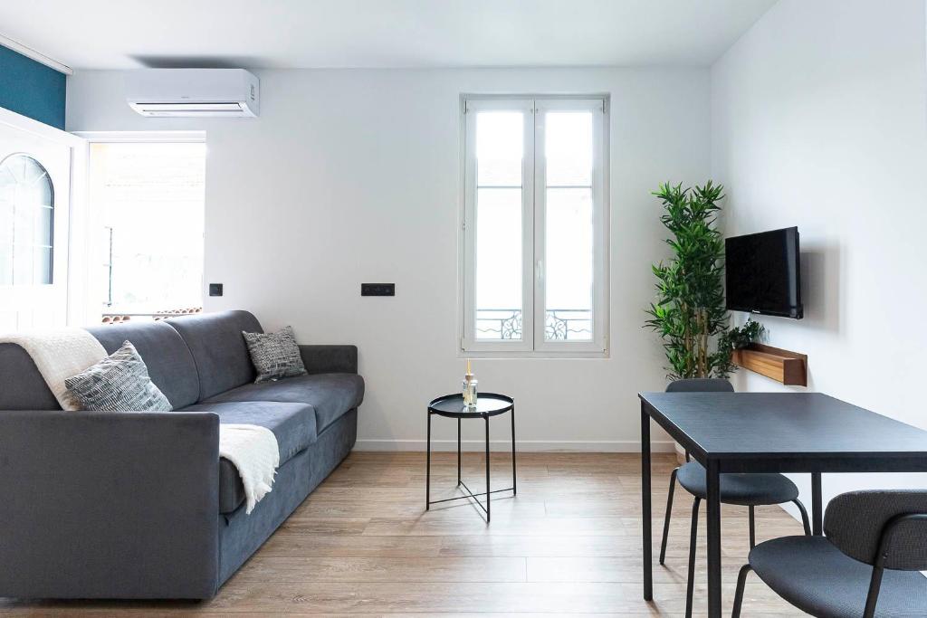 un salon avec un canapé et une table dans l'établissement Villa Maska - Studios avec Terrasse proche plage et aéroport de Nice, à Nice