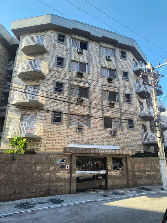 un grande edificio in mattoni con finestre e balconi di Apartamento para temporada em Cabo Frio a Cabo Frio