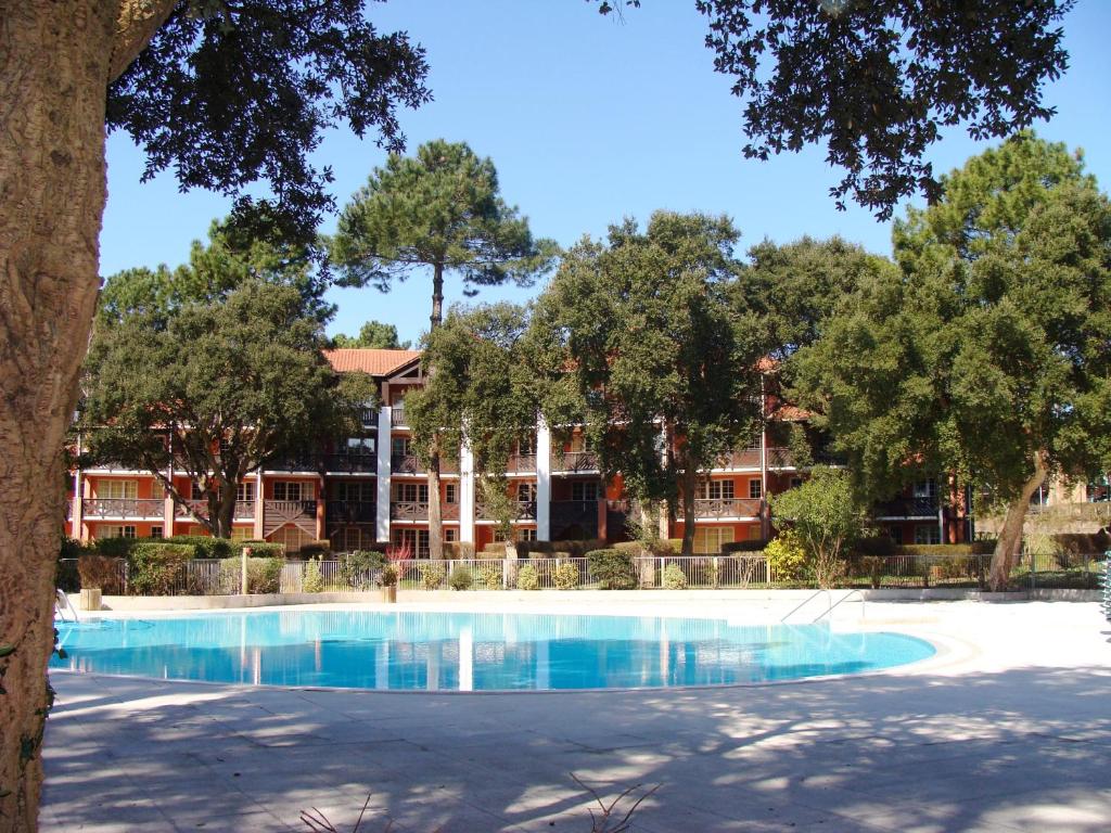 une piscine devant un immeuble avec des arbres dans l'établissement Maryse, à Moliets-et-Maa