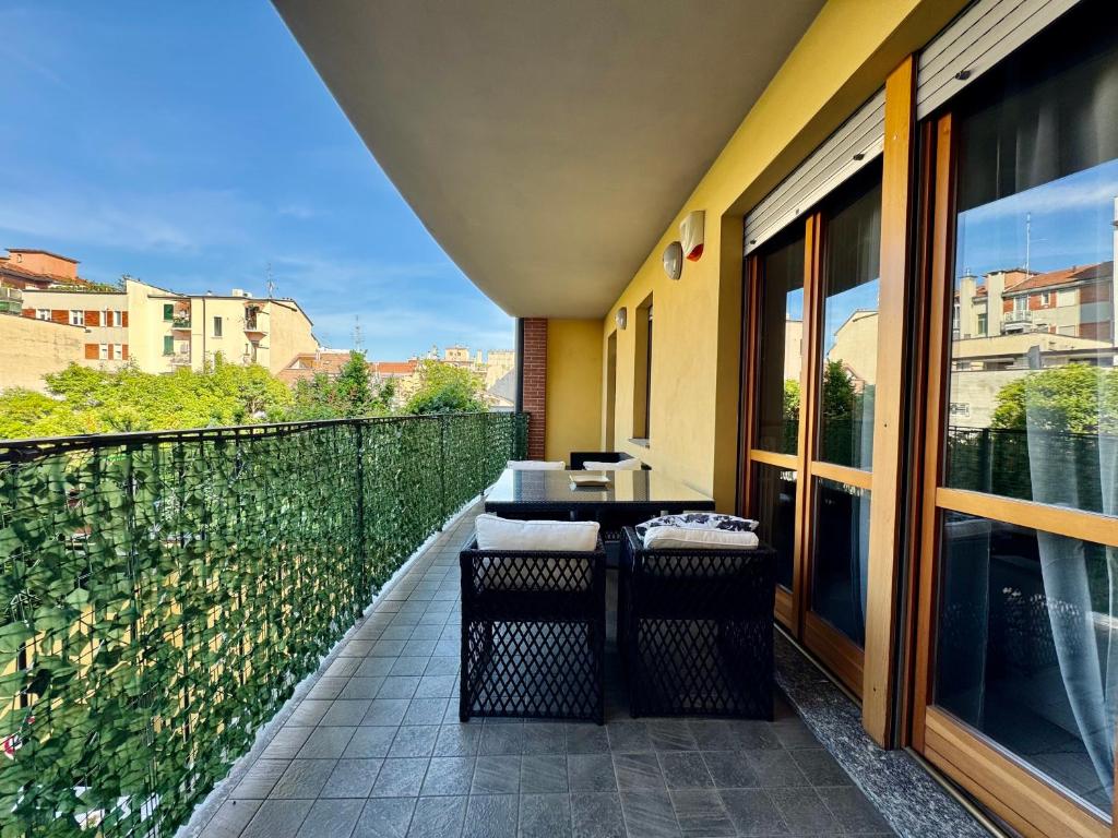 a balcony with a table and chairs on a building at Spacious 2-Bedroom Apartment with Large Terrace in Milan