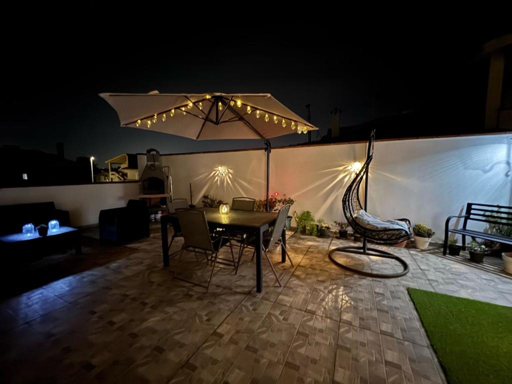 a patio with a table and chairs and an umbrella at Incanto in Sestu