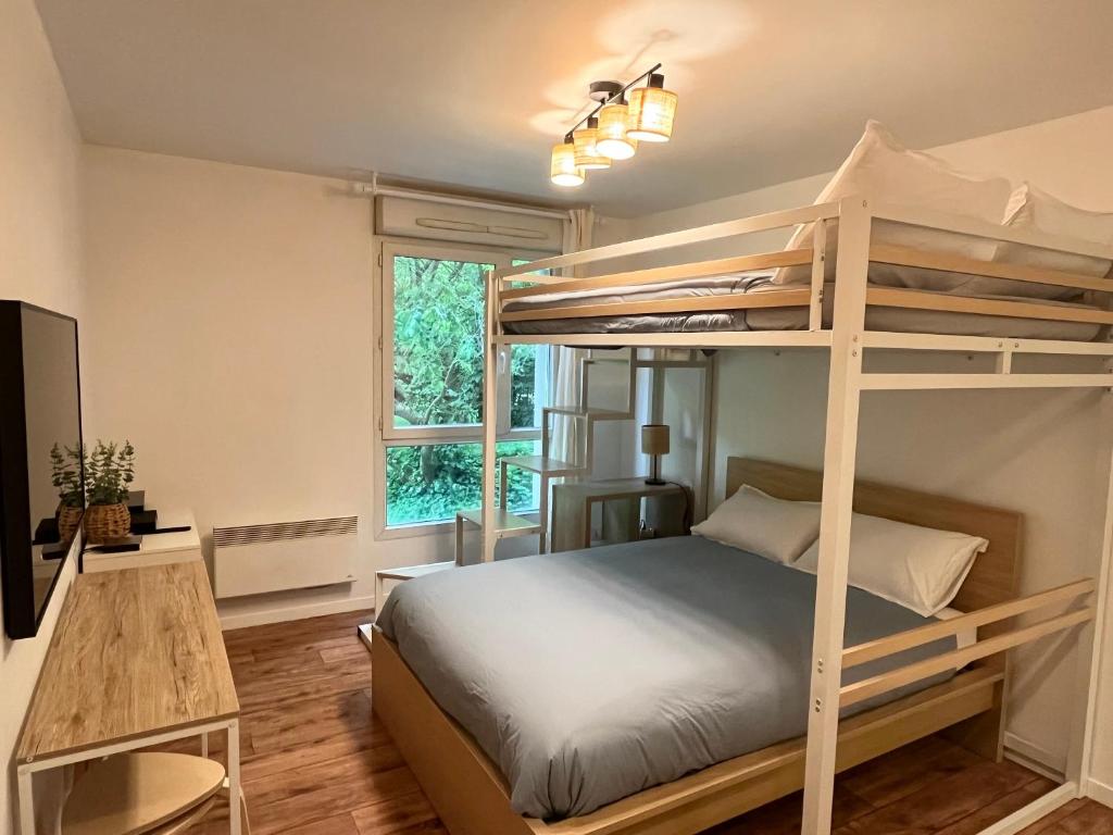 une chambre avec un lit superposé et un bureau dans l'établissement Cosy Studio Disney Paris RER A, à Montévrain