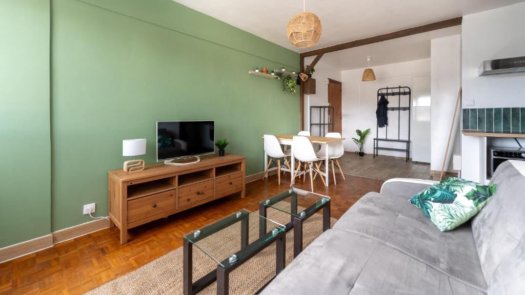 un salon avec un canapé et une télévision à écran plat dans l'établissement T2 Parking à 1000m du Lac, à Annecy