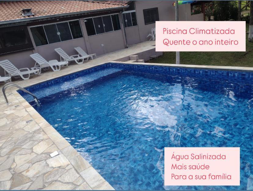 une piscine avec un panneau en face d'un bâtiment dans l'établissement Recanto dos Passaros, à Socorro