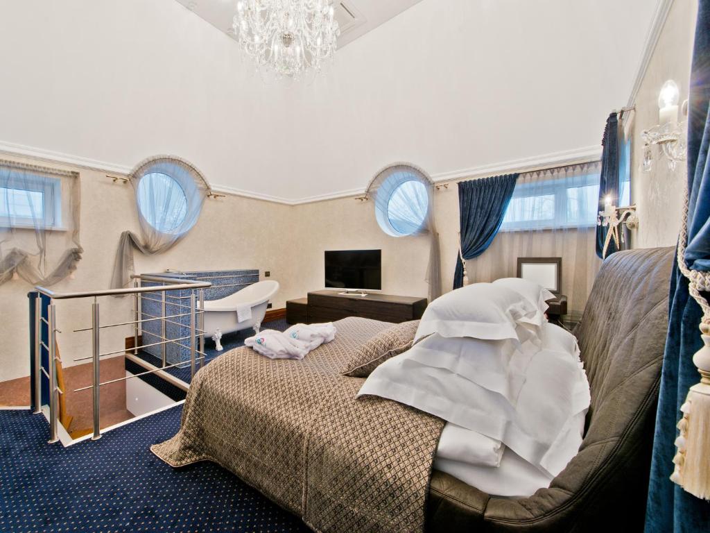a bedroom with a bed and a couch and windows at Aqua Center Apartments in Druskininkai