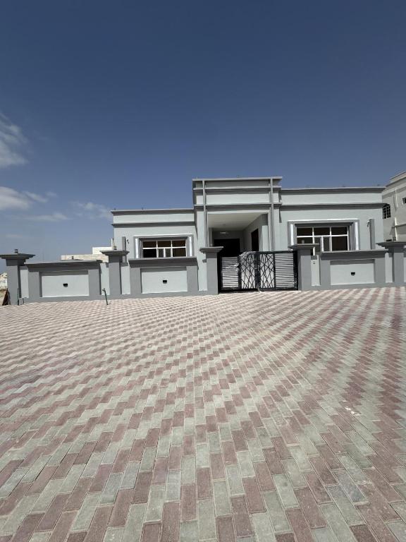 a large white house with a large driveway at منزل لافيدا La Vida Home in Salalah