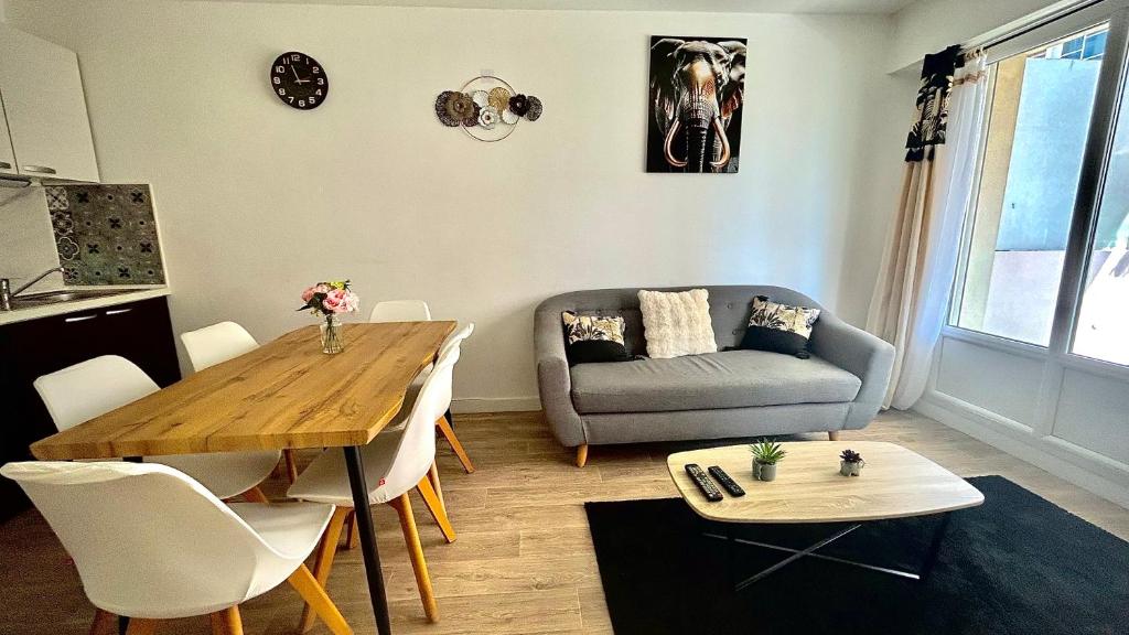 un salon avec une table et un canapé dans l'établissement T3 Cosy Coeur Aix Les Bains avec 2 Balcons, à Aix-les-Bains