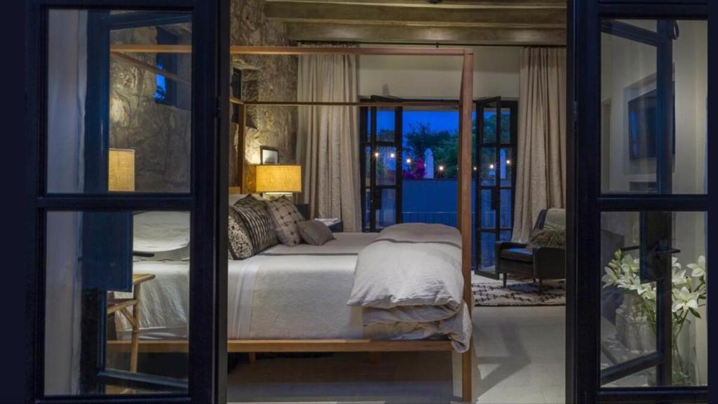 サンミゲル・デ・アジェンデにあるCasa Zenaida in the heart of San Miguel Allendeのベッドルーム1室(ベッド1台、ガラスドア付)
