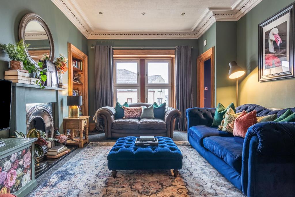 sala de estar con sofás azules y chimenea en The Nessting Place, en Inverness