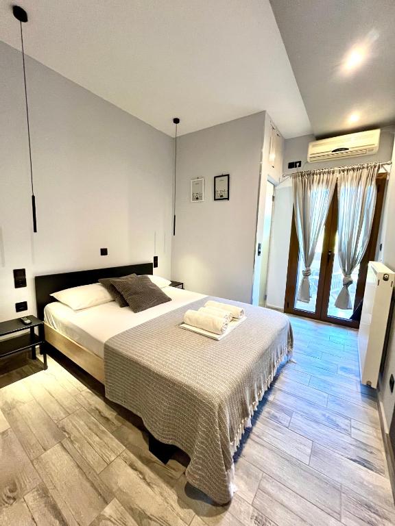 a bedroom with a large white bed and windows at Oihalia's petit DOUBLE ROOM in Khánia