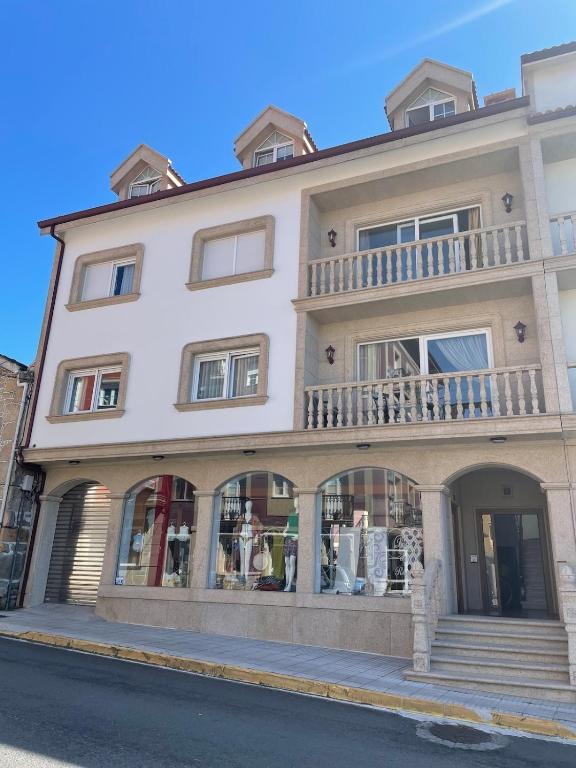 a large white building with a balcony on a street at Apartamento céntrico Playa de Carnota in San Mamede de Carnota