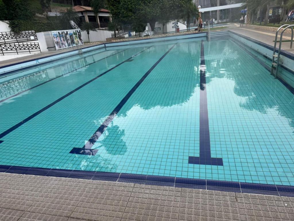 a woman swimming in a swimming pool at Apto a 100 metros das piscinas Balneário Piratuba in Água Doce