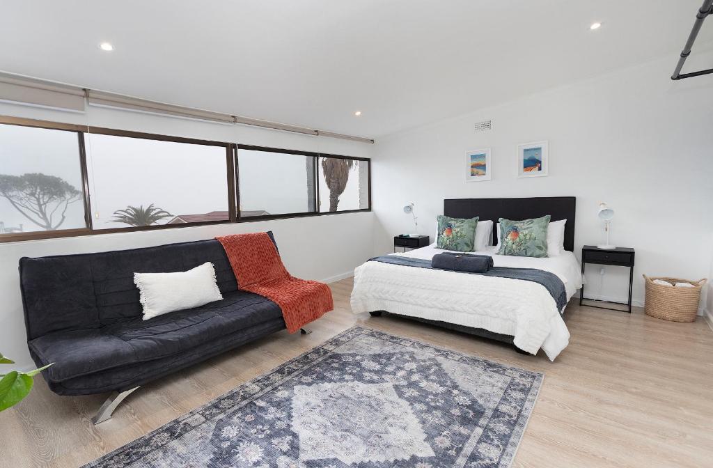 a bedroom with a bed and a couch at Camps Bay private room and bathroom in Cape Town