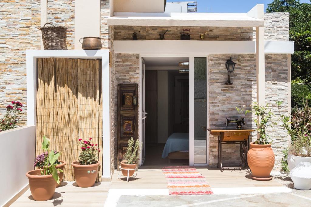 une terrasse avec des plantes en pot et une porte ouverte dans l'établissement DTS apartment, à Réthymnon