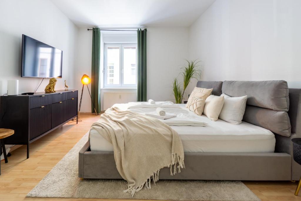 Un dormitorio con una cama grande y un televisor. en Sleep better here! central oasis of well-being, en Graz