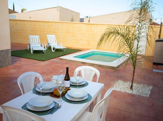 une table et des chaises blanches ainsi qu'une piscine dans l'établissement Villas Privadas EL DESCANSO, à La Rinconada