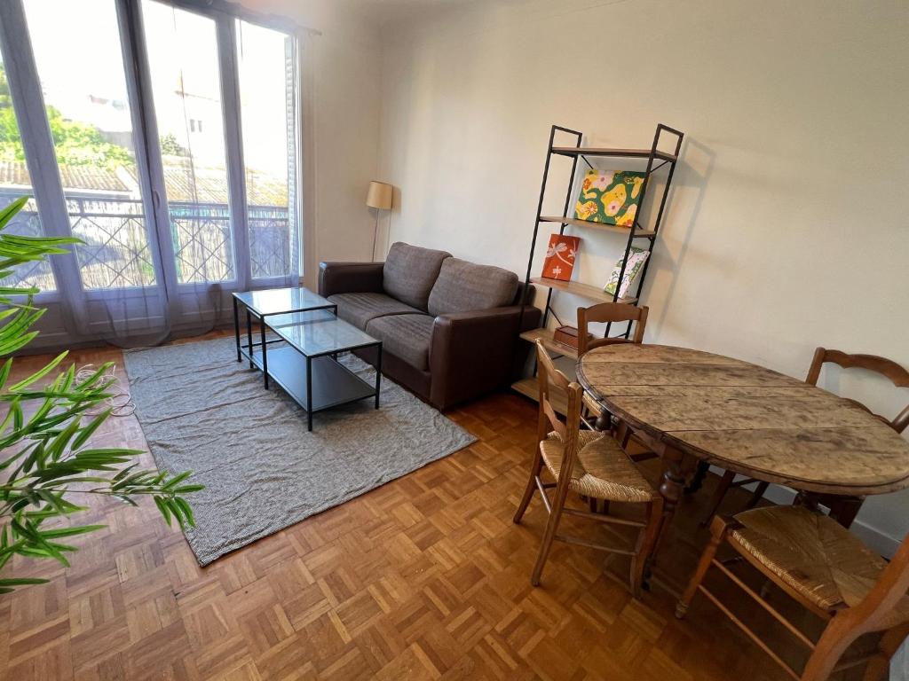 un salon avec un canapé et une table dans l'établissement Joli appartement à Montreuil, proche des nouvelles stations de métro, à Montreuil