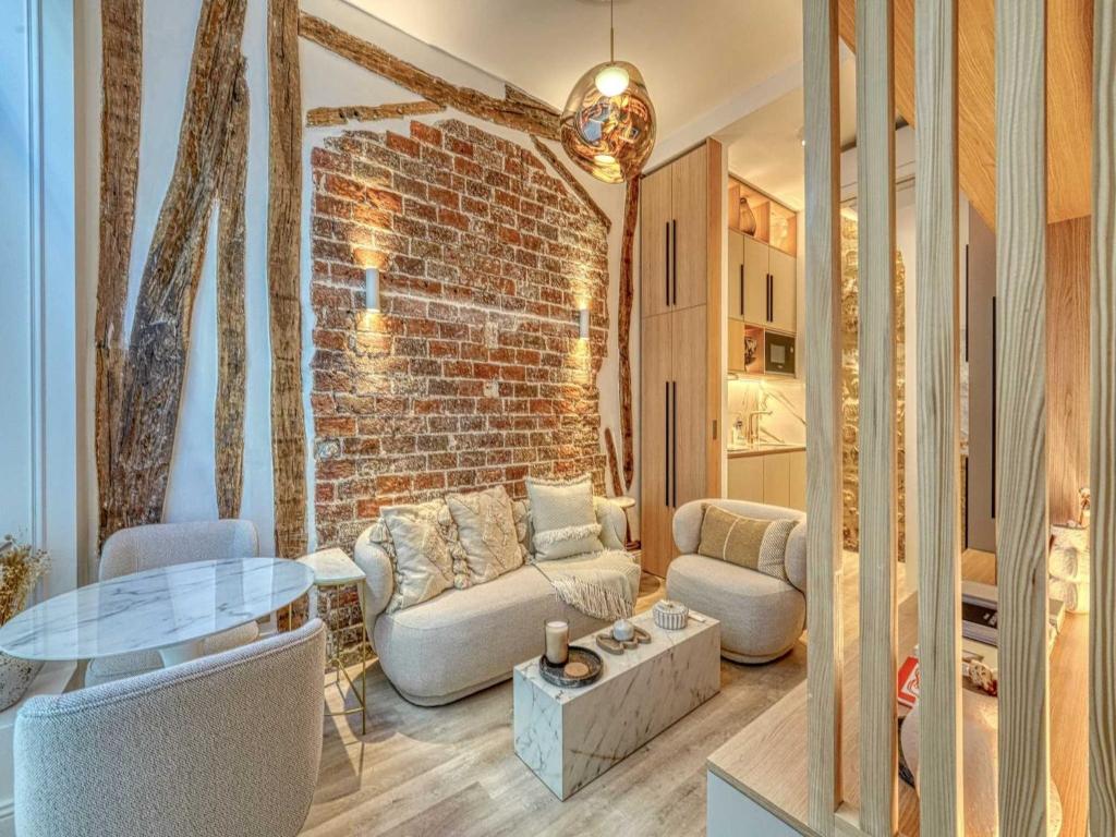 un salon avec un mur de briques dans l'établissement Central historic loft by architect, near Louvre, à Paris