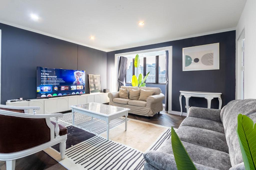 ein Wohnzimmer mit Sofa und Tisch in der Unterkunft Omni Nuvél 4 Sukhumvit Branded Suites in Bangkok