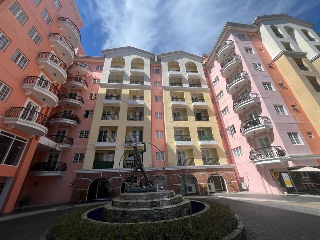 two large pink buildings with a statue in front of it at Villa Brune in Baguio