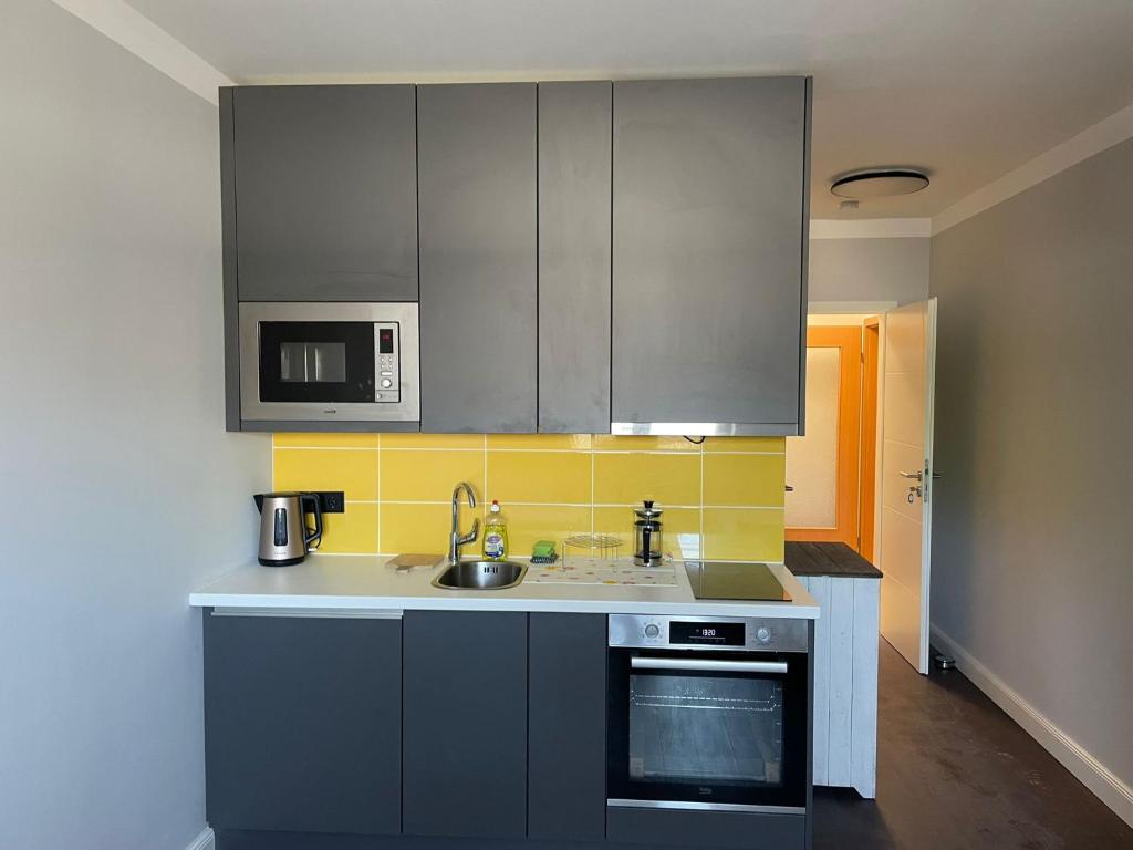 a kitchen with stainless steel cabinets and a sink at neu renoviert private zimmer mit Bad und Küche in Rostock