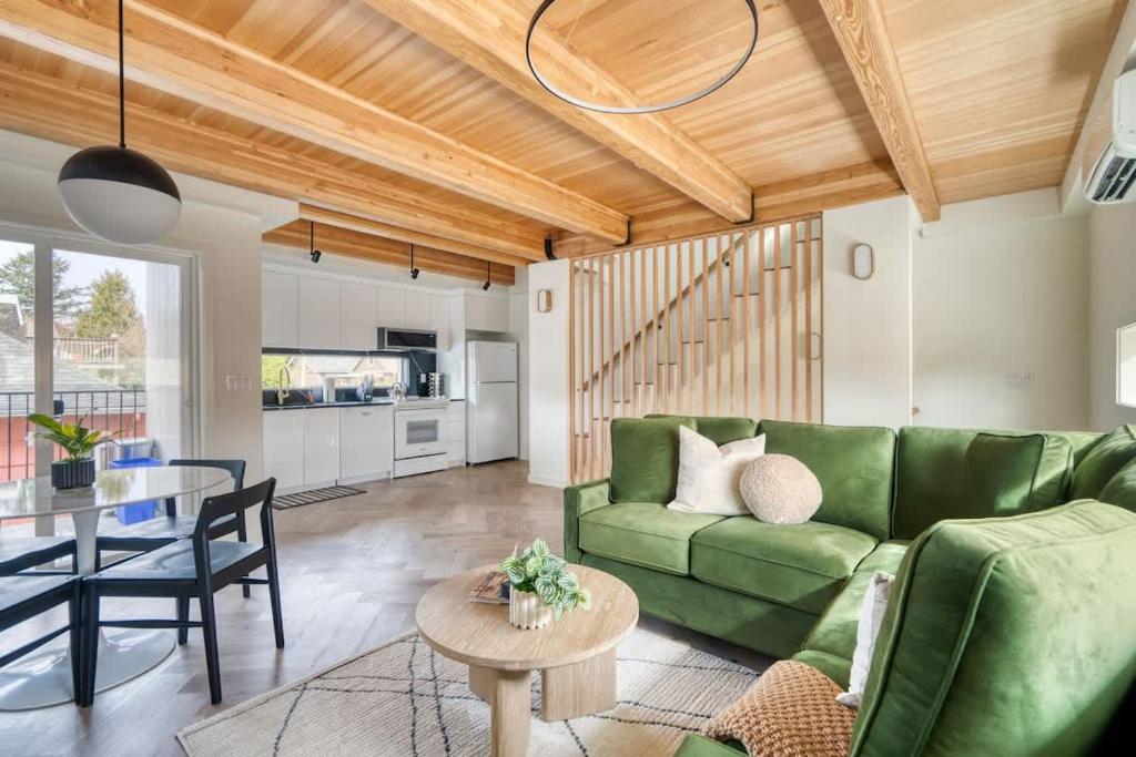 un soggiorno con un divano verde e un tavolo di Alberta Arts District Hideaway- Stylish Townhome a Portland