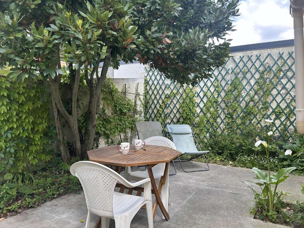 une table et des chaises en bois sur une terrasse dans l'établissement Charmante maison 2 pièces à Saint-Gilles-Croix-de-Vie - FR-1-224-818, à Saint-Gilles-Croix-de-Vie