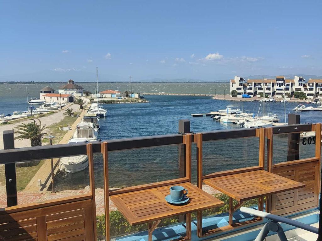 d'un balcon avec une table et une tasse. dans l'établissement T2 Mezzanine Climatisé avec Parking au Bord de l'Eau - FR-1-195-118, au Barcarès