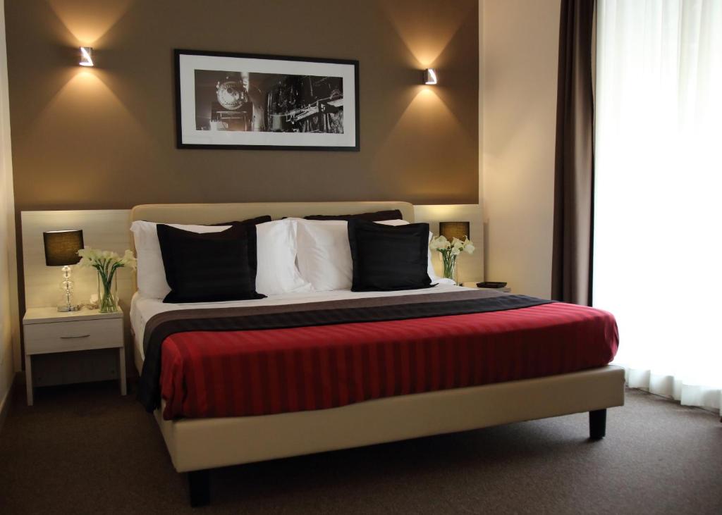 1 dormitorio con 1 cama grande con manta roja en Stelle Hotel The Businest en Nápoles