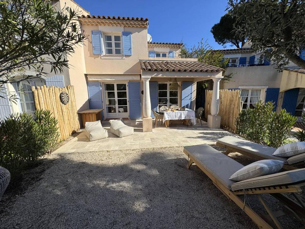 une maison avec un patio avec une table et des chaises dans l'établissement Maison rénovée 2 chambres, terrasse vue mer - FR-1-726-63, à La Croix-Valmer