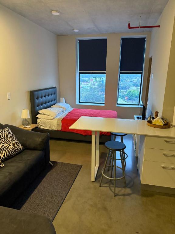 a bedroom with a bed and a desk with a table at Studio Apartment URBN Escalante in San José