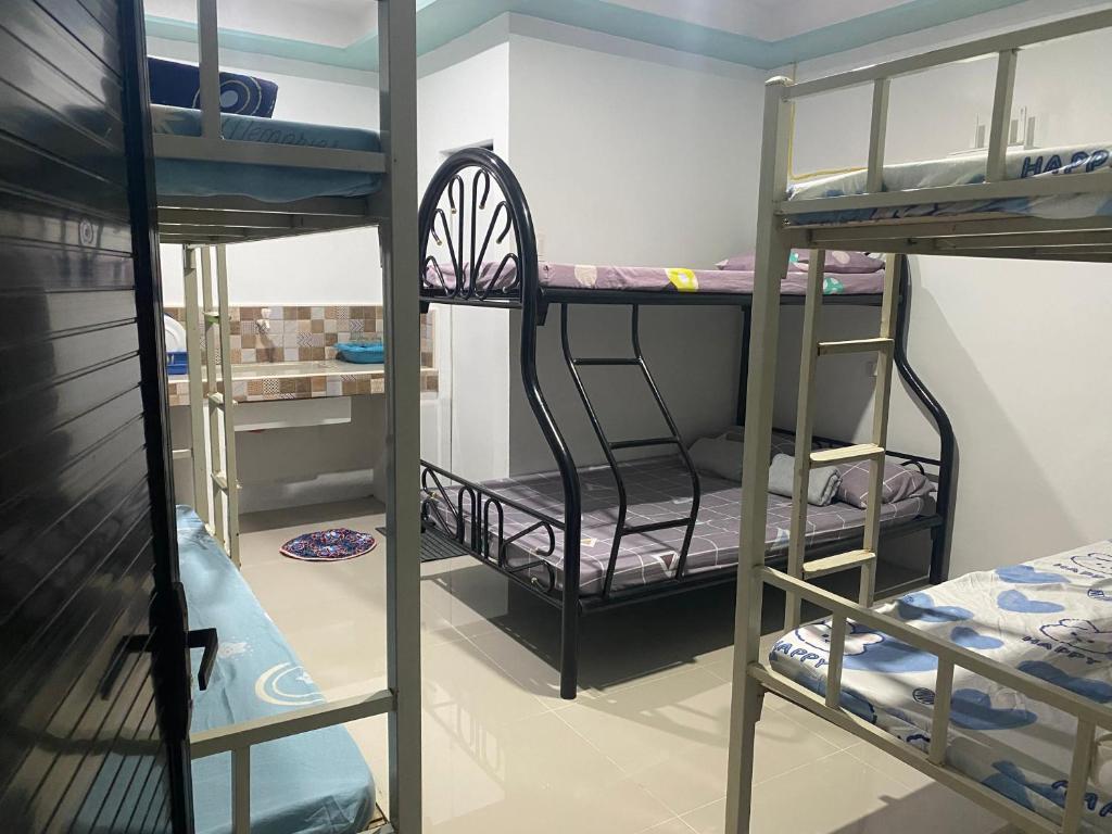 a room with three bunk beds in a room at Leonisa Transient House in Mariveles