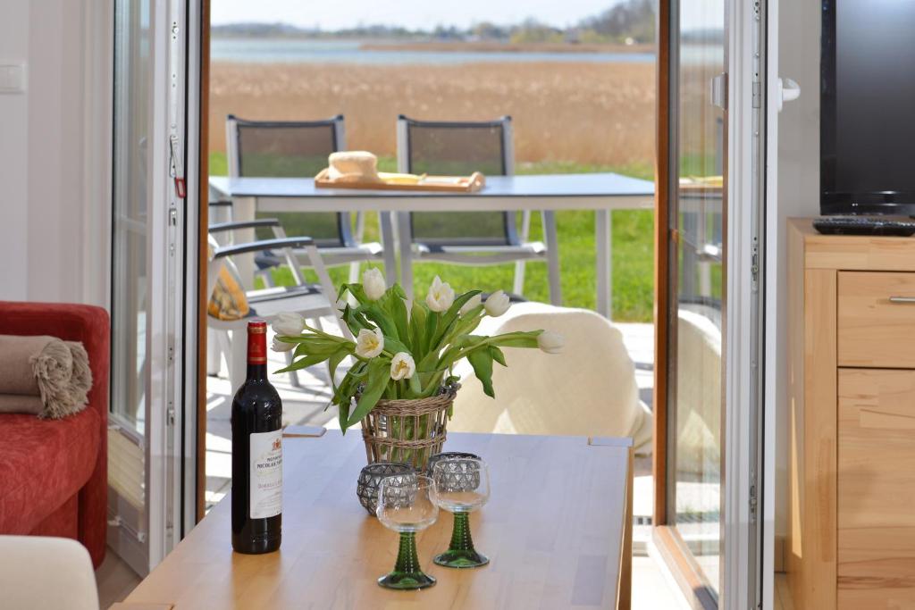 einen Tisch mit Weingläsern und eine Vase mit Blumen in der Unterkunft Ferienhaus "Ostseebrise" in Breege