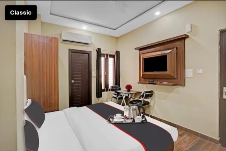 ein Hotelzimmer mit einem Bett und einem Fernseher in der Unterkunft Hotel Green Apple BAREILLY in Bareilly