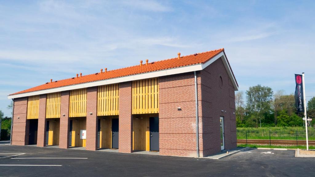 um edifício de tijolos com telhado laranja em Hotel Torpedoloods em Hoek van Holland