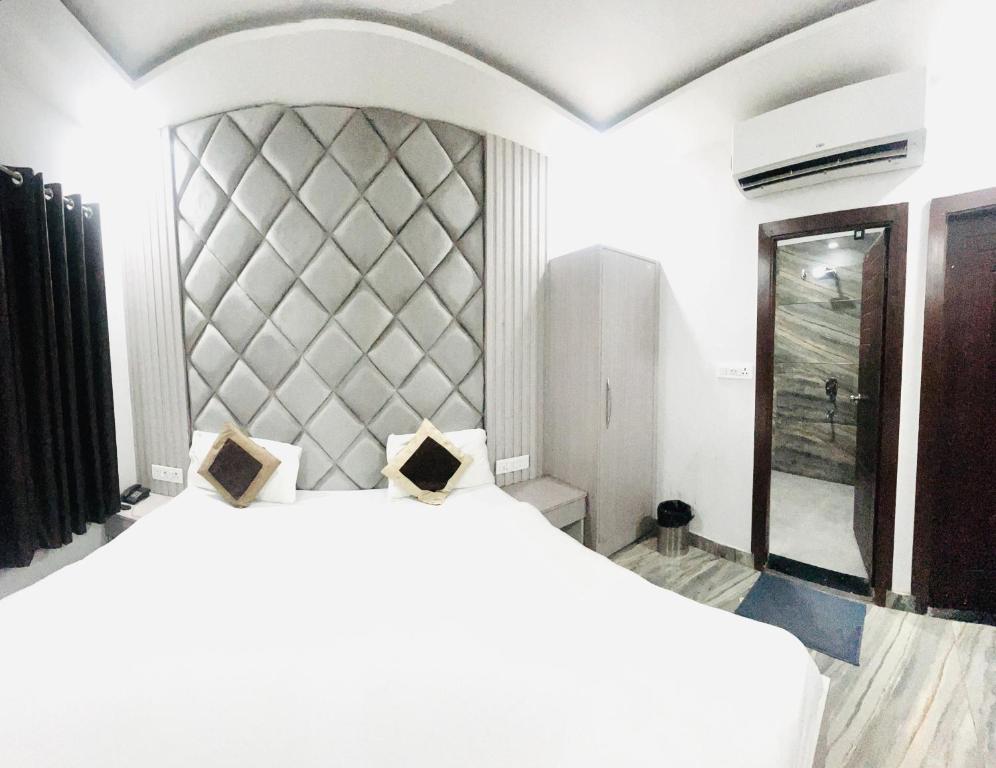 ein Schlafzimmer mit einem großen Bett und einem großen Spiegel in der Unterkunft Hotel Green Apple BAREILLY in Bareilly