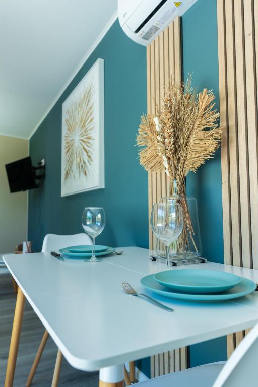 - une table à manger blanche avec des assiettes et des verres dans l'établissement La Tiny L Loches, proche Zoo de Beauval, à Loches